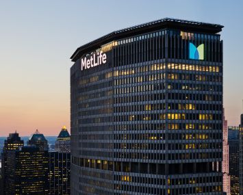 The top of a large skyscraper with the word "MetLife" in glowing letters on the top.