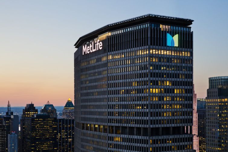 The top of a large skyscraper with the word "MetLife" in glowing letters on the top.