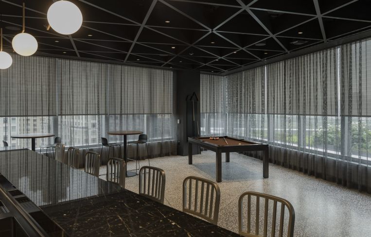 A conference table with a pool table behind it.
