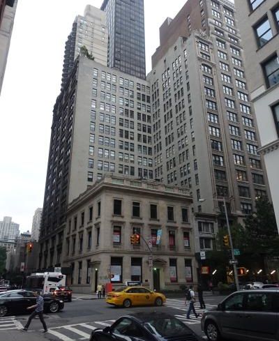 A large grey building with one lower portion in an L shape.
