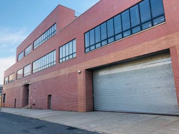 A large red brick warehouse with a garage.