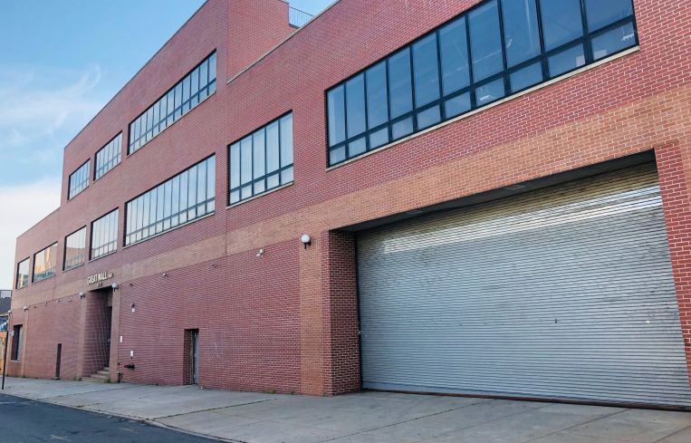 A large red brick warehouse with a garage.