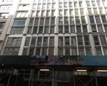 A grey building with a green awning.