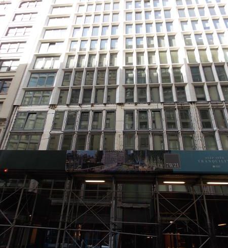 A grey building with a green awning.