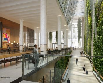 A large open atrium with a green, plant-covered wall and pillars.
