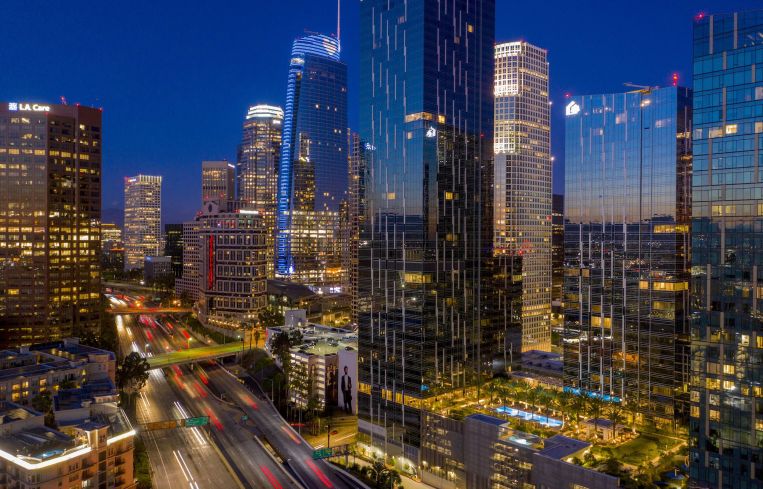 An aerial view shows increasing traffic on the Interstate 110 freeway near high-rise buildings.