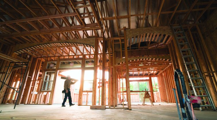 A large, spacious wooden structure with a worker walking through it.
