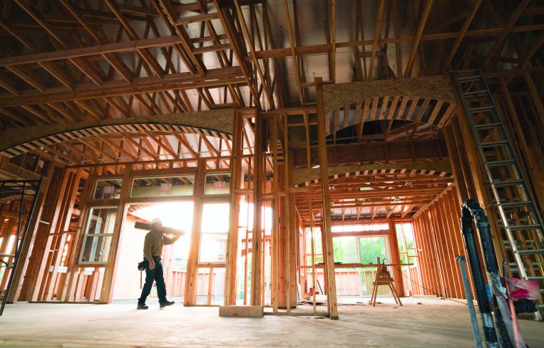 A large, spacious wooden structure with a worker walking through it.