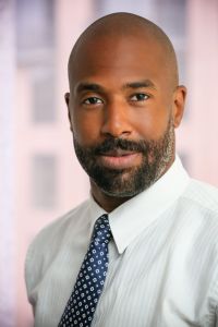 A bearded man in a tie looking into the camera.