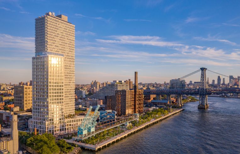 A tall building on Brooklyn's waterfront peaks out above the New York skyline.