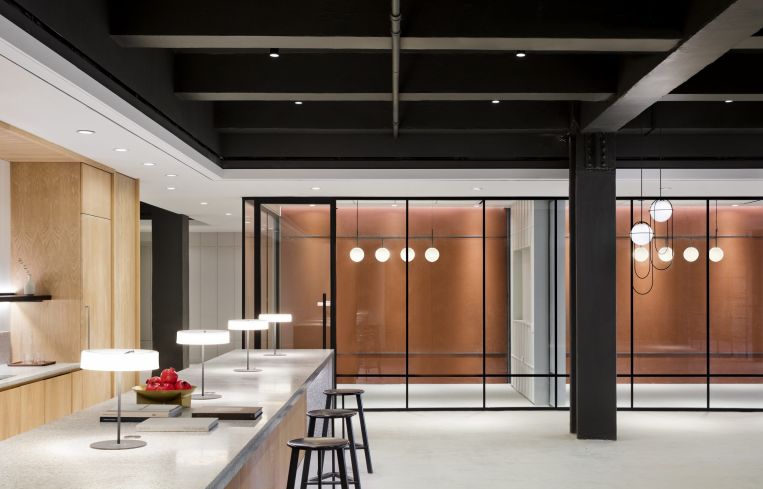 The prebuilt suite upstairs has a kitchen with wood paneled cabinetry and terrazzo bar.