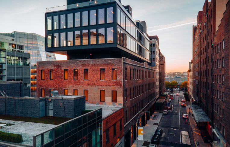 A large warehouse with a steal structure on top of it backed by a river.