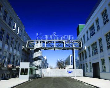 A large studio lot with a sign at the center and two buildings flanking the sign.