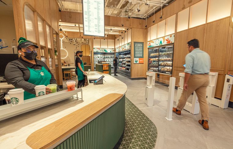 Customers mill about A cashierless Starbucks store.