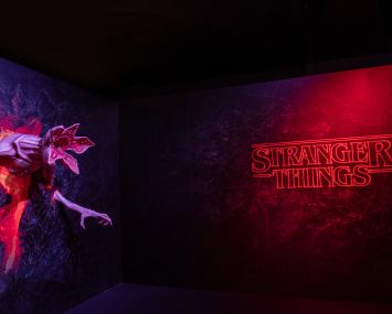 The words "Stranger Things" lighted in red with a monster protruding from the wall.