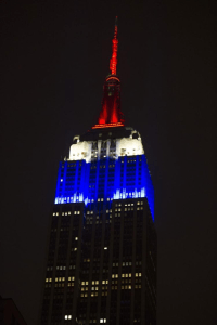 The Empire State Building lit up in blue red and white.
