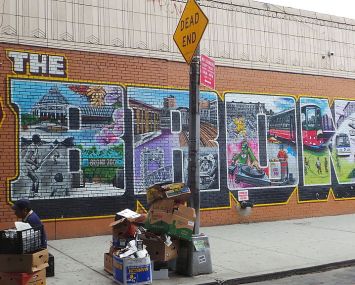 A brick wall with The Bronx artistically designed on it.