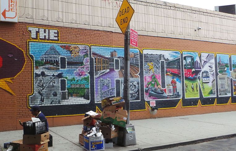 A brick wall with The Bronx artistically designed on it.