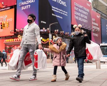 A family of three walk in Times Square in New York City.