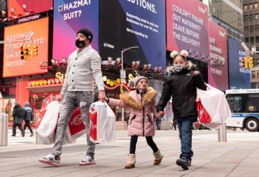 A family of three walk in Times Square in New York City.