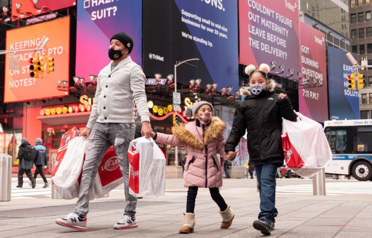 A family of three walk in Times Square in New York City.