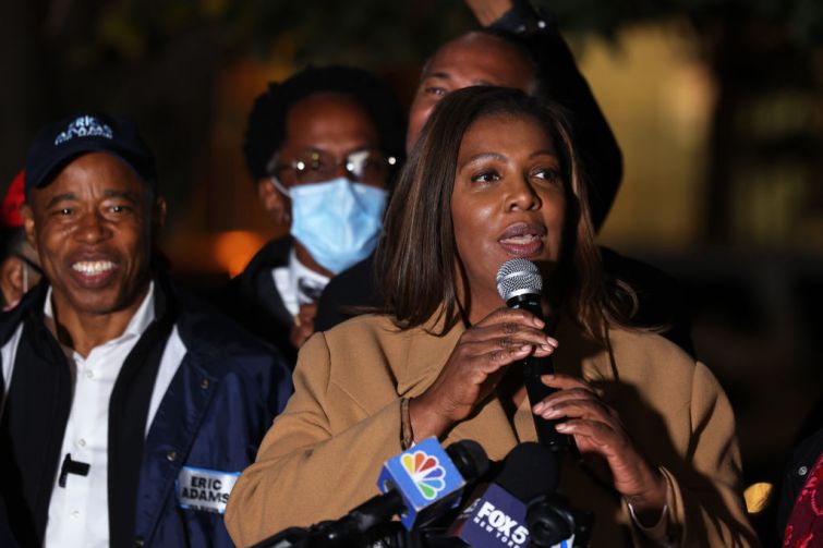 Letitia James stands with a microphone in her hands at a podium.