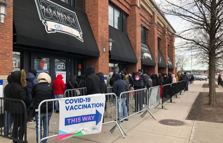 People queue up outside a COVID-19 vaccination site in the Queens borough on December 23, 2021 in New York City.