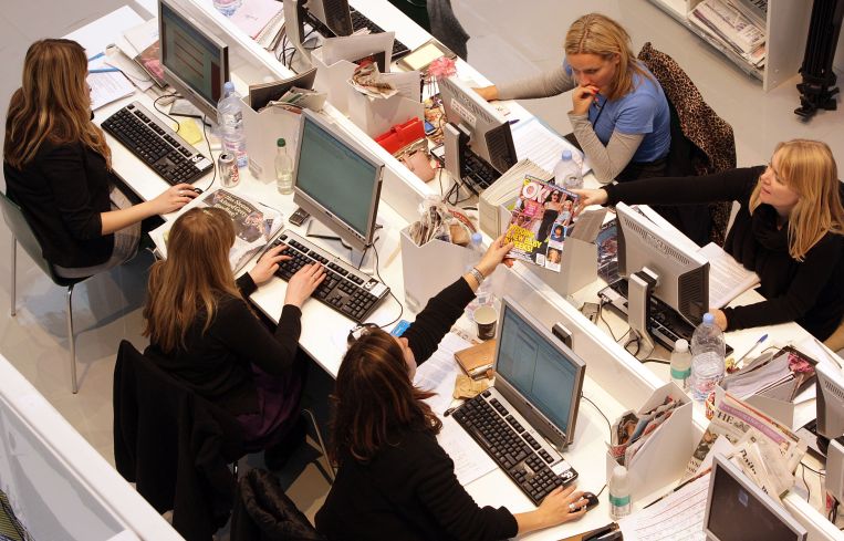 People and their computers along either side of a long table.