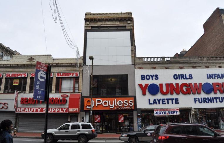 The short building at 162-11 Jamaica Avenue, pictured with a Payless and clothing store.