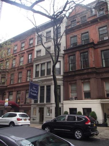 The shorter upper east side building 22 East 80th Street, home to two galleries, with two cars parked out front.