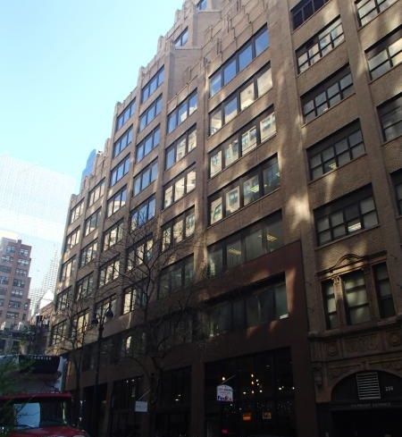 The large brown office building at 228 East 45th Street, from the perspective of one on the street below, with large rectangular windows.
