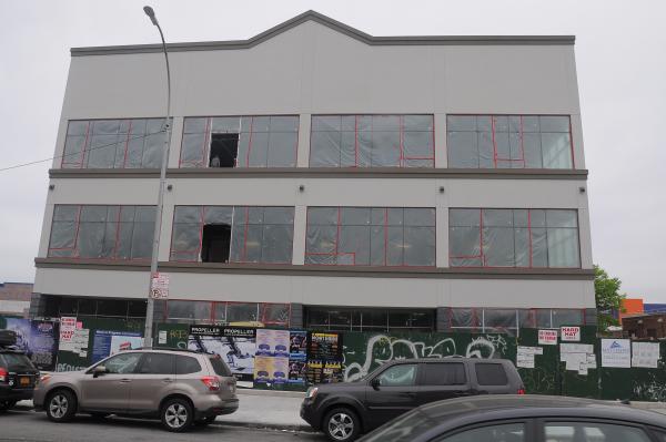 The three-story building at 340 Fourth Avenue, viewed from Fourth Avenue, with large grey windows facing the viewer.