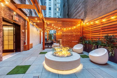 SJP Properties turned an unused rear yard into an outdoor amenity space with a firepit, seating and a bar. 