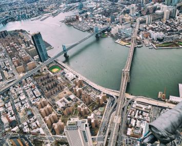 New York City from helicopter point of view. Brooklyn, Manhattan and Williamsburg Bridges with Manhattan skyscrapers on a cloudy day.