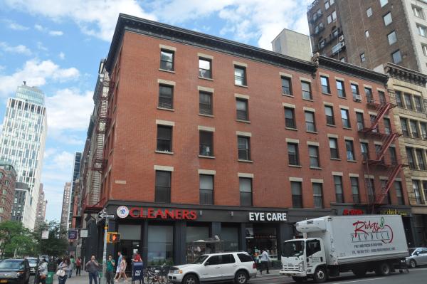The block of red brick and grey buildings at 80 to 88 West Broadway and 70 to 74 Warren Street.