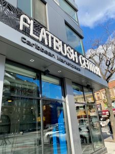 The large glass and grey sign outside Flatbush Central, the new location for the Caribbean market in Brooklyn.