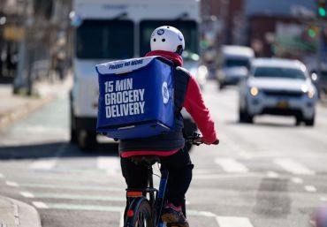 An employee rides a bike to deliver groceries from 'Fridge No More' on March 31, 2021 in the Brooklyn borough of New York City.