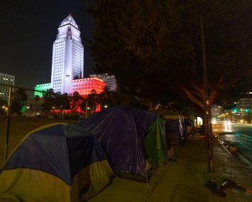 Homeless encampments are seen near the Los Angeles City Hall, which is lit in the colors of the Mexican flag. In 2020, the city saw a 16.1 percent rise in homelessness to an estimated 41,290 people.