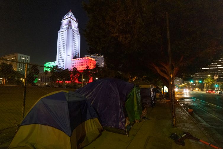 Homeless encampments are seen near the Los Angeles City Hall, which is lit in the colors of the Mexican flag. In 2020, the city saw a 16.1 percent rise in homelessness to an estimated 41,290 people.