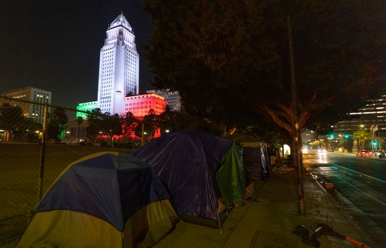 Homeless encampments are seen near the Los Angeles City Hall, which is lit in the colors of the Mexican flag. In 2020, the city saw a 16.1 percent rise in homelessness to an estimated 41,290 people.