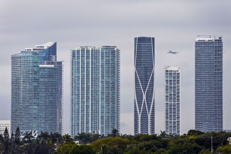 A plane flies over Miami residential towers in Miami, Florida, on January 20. The increase in real estate prices in South Florida is one of the highest in the US. With its favorable climate, white sandy beaches and lack of income tax, the Miami area was already an attractive destination before COVID-19, and the pandemic has added to the phenomenon.