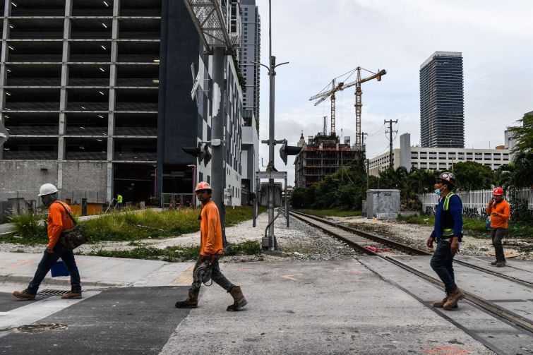 Construction workers arrive at a site for a residential tower in Miami, Florida in January. South Florida commercial real estate investment increased by 179 percent in 2021 compared to 2020.