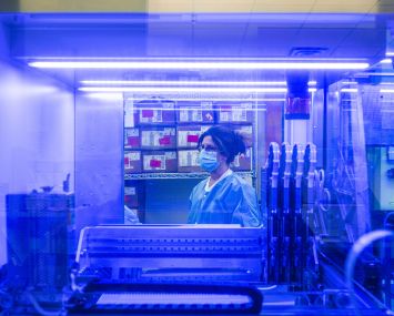 Lisa Bates, a medical technologist is seen through the window of a PCR analysis machine in the PCR testing lab at Quest Diagnostics in February 2022 in Indianapolis, Indiana. The lab is capable of processing up to 3700 tests per day.