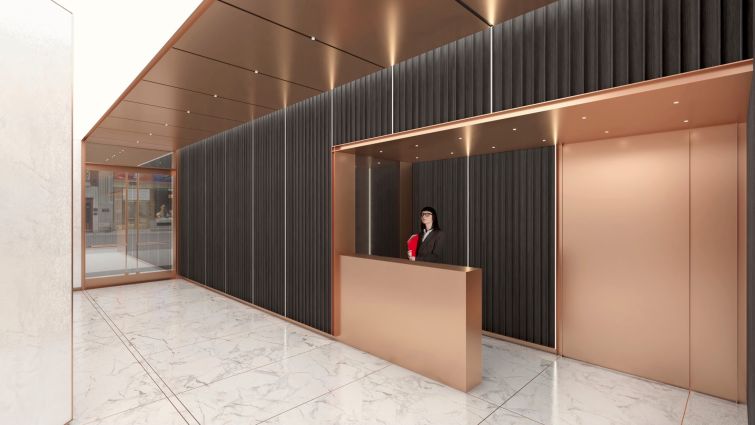 The new lobby includes rose gold paneling throughout, including on the ceiling, reception desk and elevator doors.