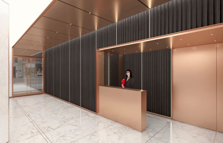The new lobby includes rose gold paneling throughout, including on the ceiling, reception desk and elevator doors.
