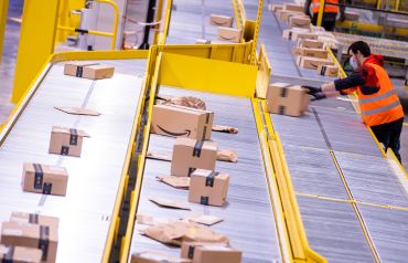 Employees sort parcels from online retailer Amazon at a new distribution center.