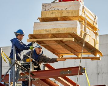 Here and below, workers install an air source heat pump at the under-construction Hudson Research Center in Manhattan.