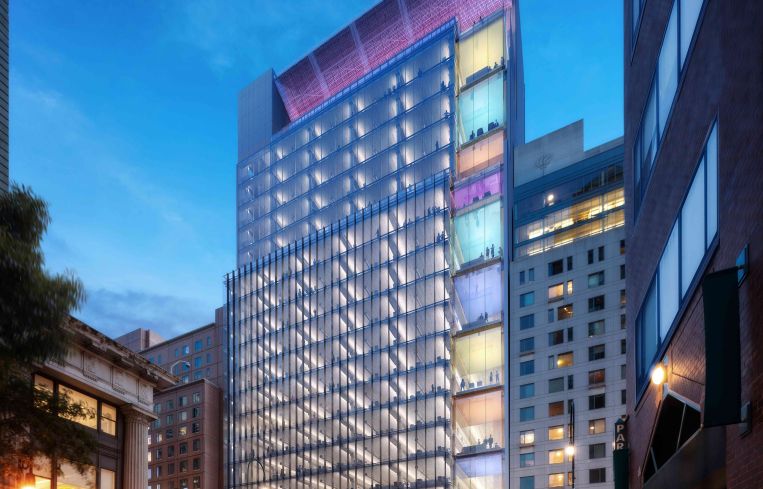 A tall steel and multicolored skyscraper in the East Village of Manhattan with its right most side covered in large windows.