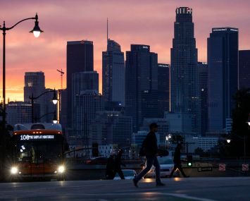 A glowing sky provides a colorful backdrop to the Downtown Los Angeles skyline, seen from Boyle Heights on March 15, 2022.