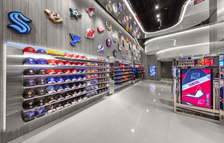 A wall of NHL team hats and pendants is arranged by the entrance of the store to draw in fans from all different teams after games at Madison Square Garden.